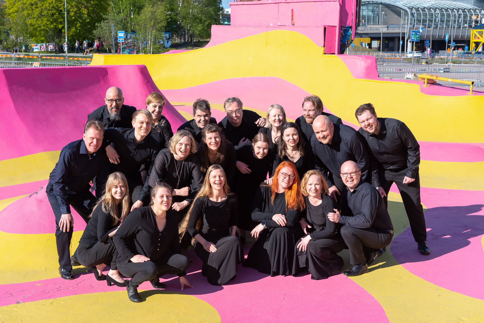 Kuorolaiset ryhmäkuvassa värikkään taustan edessä